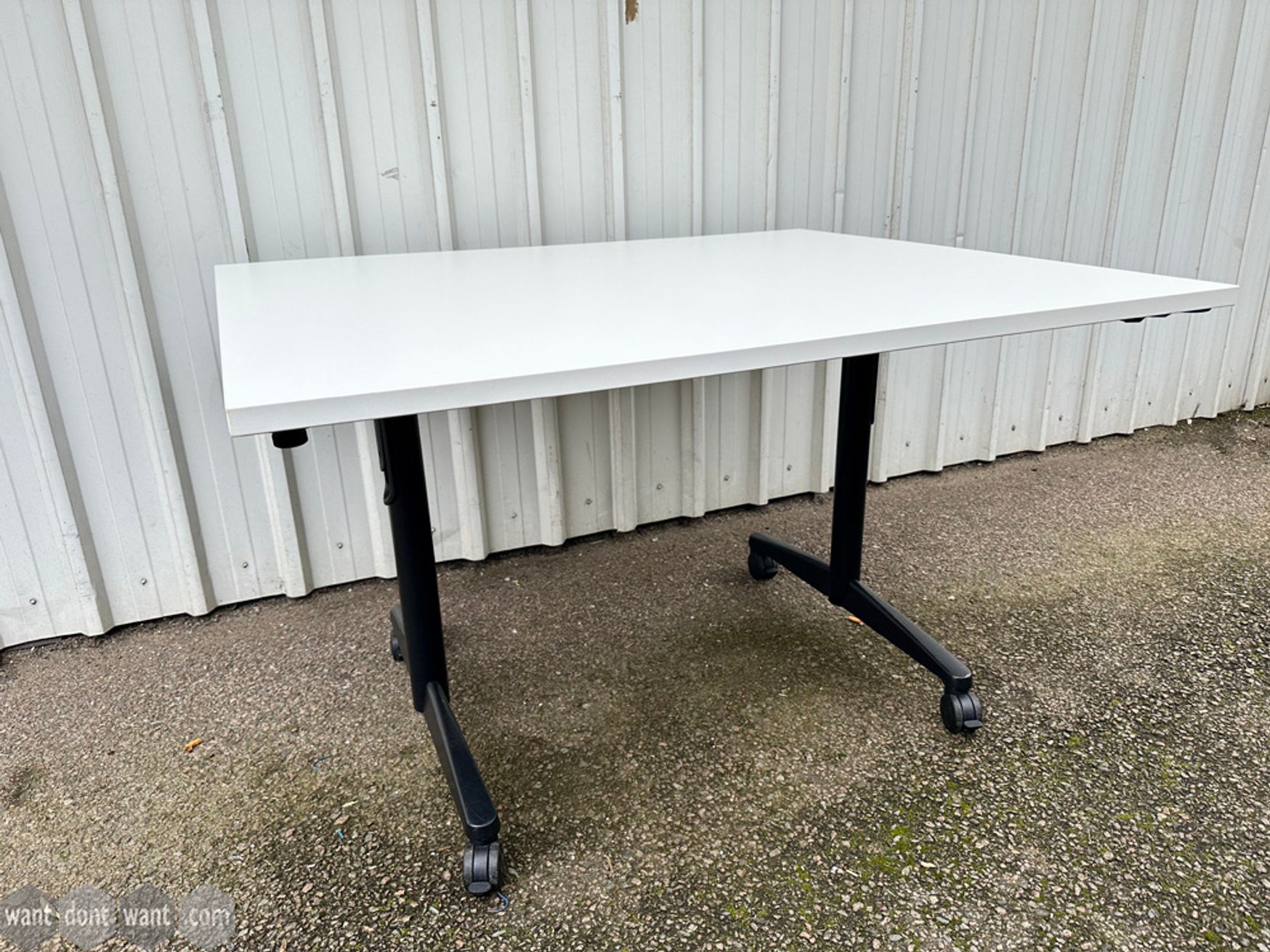 Used 1200mm folding white tables with black legs on castors.