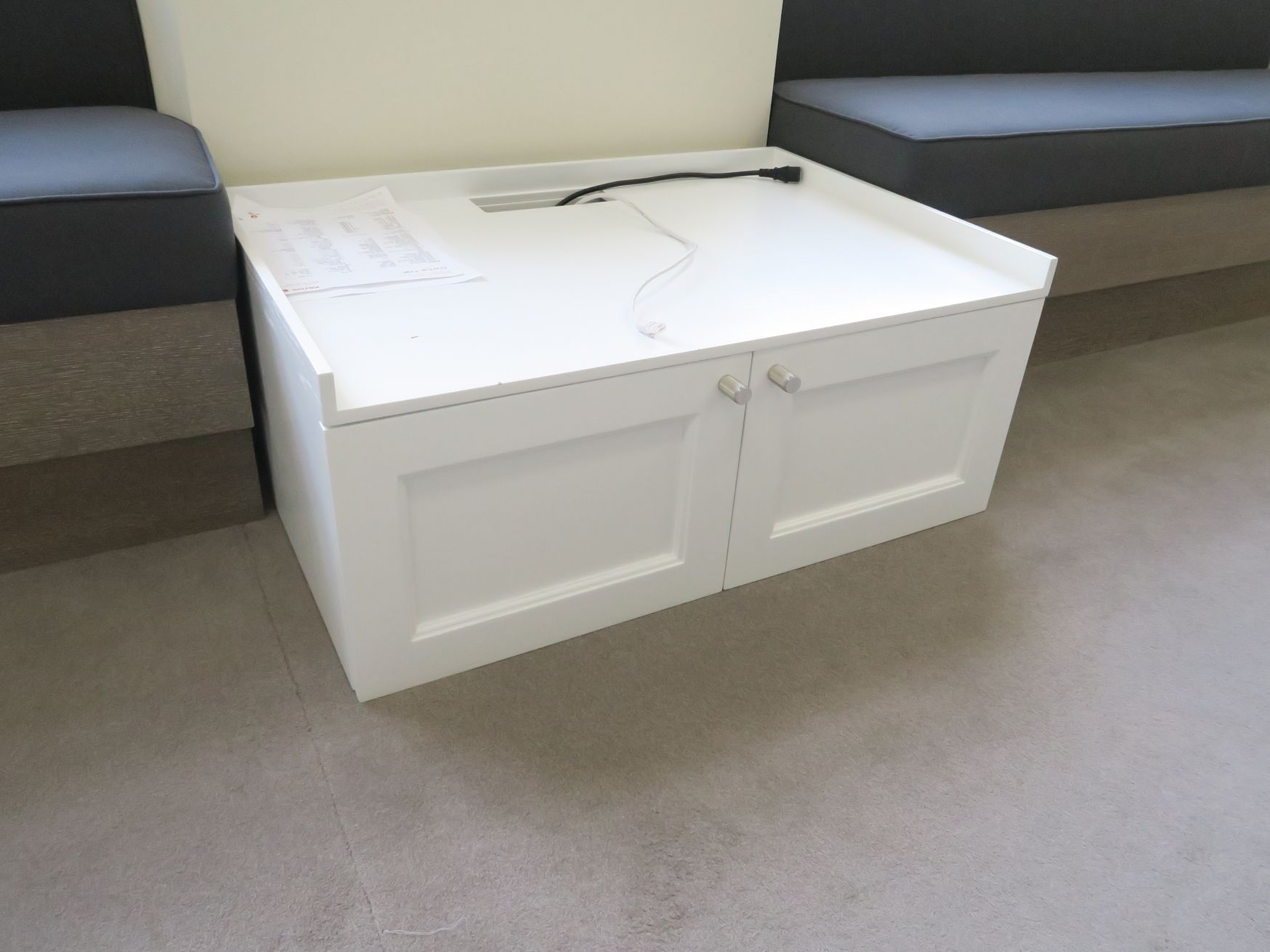 White printer table with storage below.