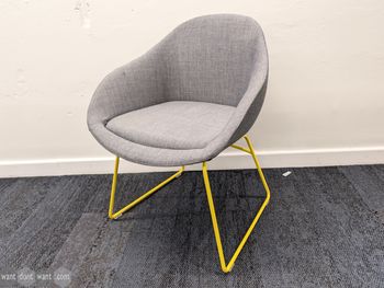 Used NaughtOne grey upholstered chair with yellow legs