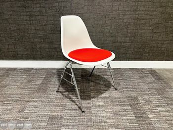 Used genuine Vitra/Eames DSS white 'Plastic Side Chairs' with red upholstered seat.